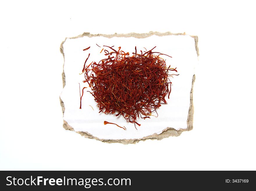 Saffron on pieces of paper with torn edges, isolated on white