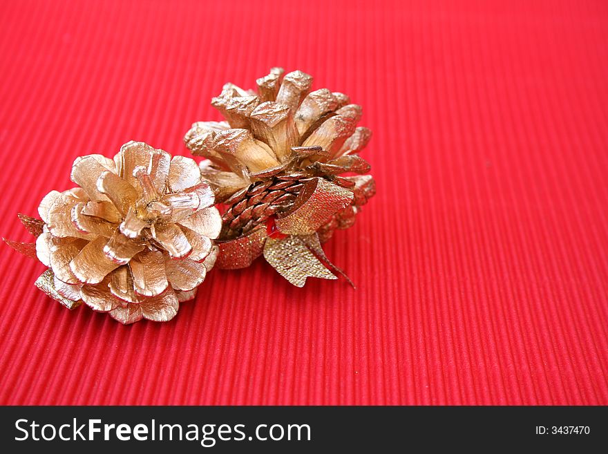 Golden decorated pine cones on a red background