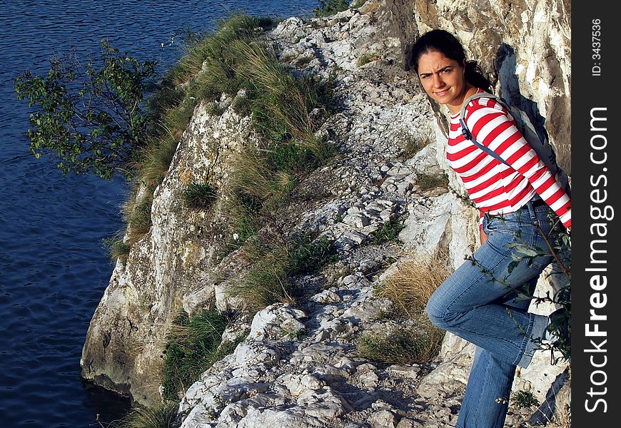 A girl, posing beside the river Danube, at the rocks, in Golubac, Serbia. A girl, posing beside the river Danube, at the rocks, in Golubac, Serbia