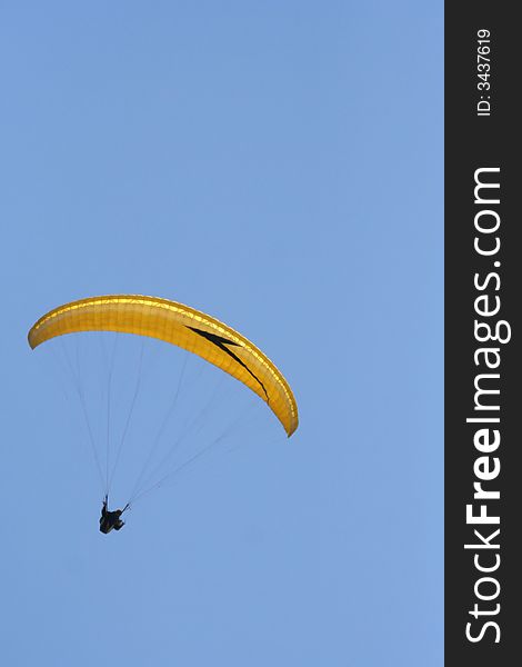 Yellow paraglider on the sky