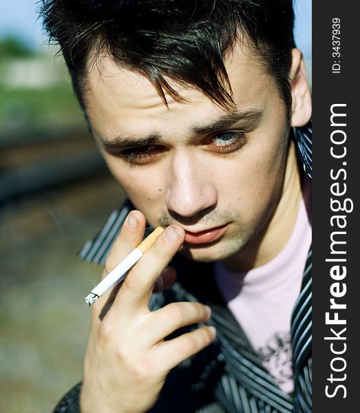 Young male smoking cigarette. Close up shot.