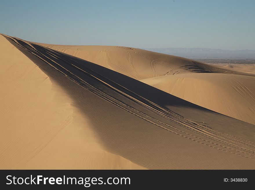 Beautiful sand dunes in Glamis California, with vehicle tracks.