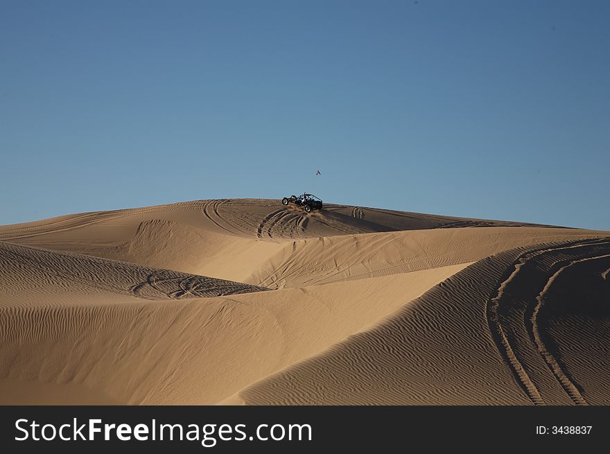 Beautiful sand dunes in Glamis California, with vehicle tracks and a sand rail at the top