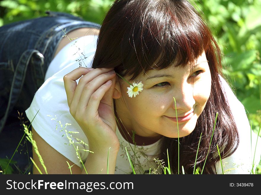 Beautiful girl lying in the grass of the garden and resting. Beautiful girl lying in the grass of the garden and resting