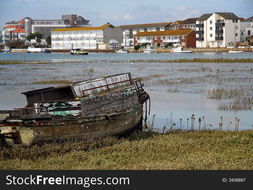 A broken boat beached in the tidal estuary. A broken boat beached in the tidal estuary