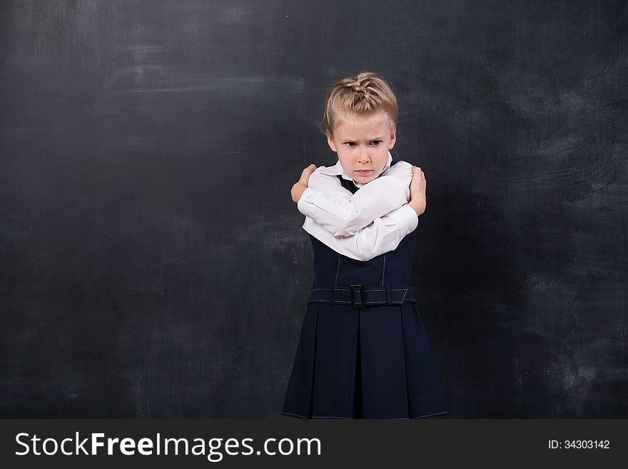 Portrait of schoolgirl leaning her forehead against blackboard