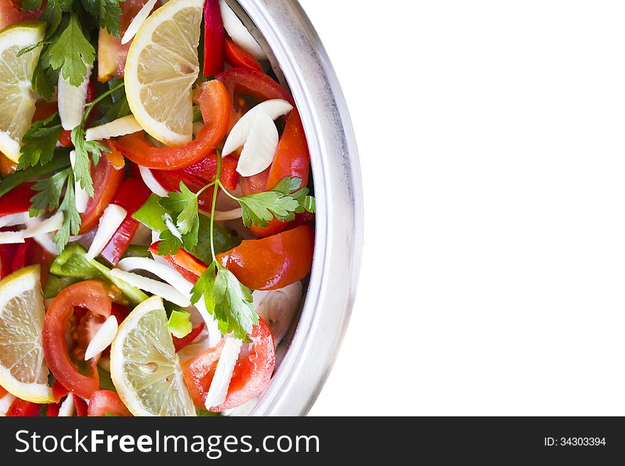 Pot and some raw ingredients on white background. The fish is cooked under the layer of vegetables. Pot and some raw ingredients on white background. The fish is cooked under the layer of vegetables.