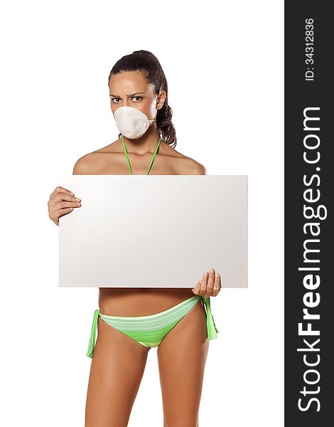 Beautiful brunette with a breathing mask in a bikini holding a blank display and pointing a finger. Beautiful brunette with a breathing mask in a bikini holding a blank display and pointing a finger