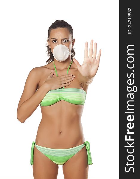 Beautiful brunette with a breathing mask in a bikini showing stop sign with her hand. Beautiful brunette with a breathing mask in a bikini showing stop sign with her hand