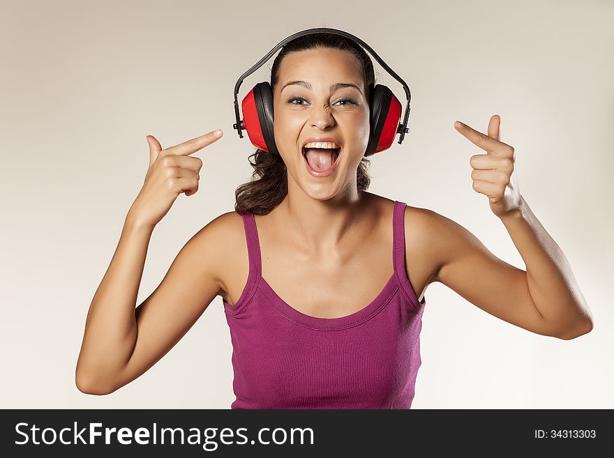 Beautiful happy young brunette can not hear because of the anti loud headset. Beautiful happy young brunette can not hear because of the anti loud headset