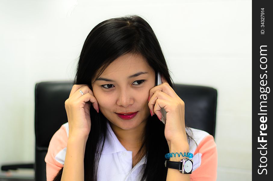 Beautiful and happy asian woman speaking on the mobile phone and relaxing