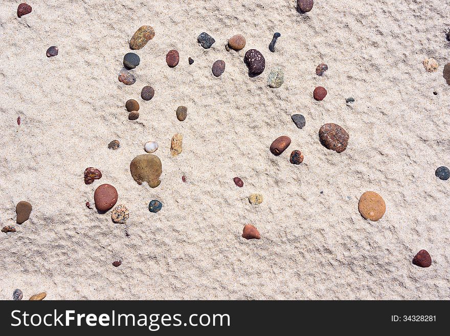 Texture of white sand with  pebbles on Baltic beach.
