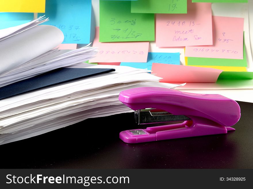 Folders with papers and stapler on a background of multicolored notes. Folders with papers and stapler on a background of multicolored notes