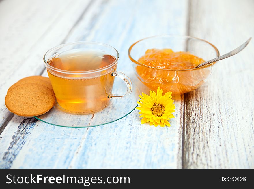 Orange jam and herbal tea on wooden table