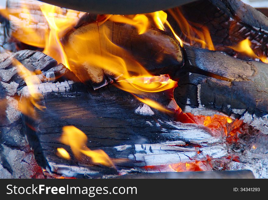 Detail of burning wooden logs in the  under the stew pot