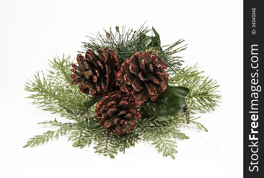 Christmas ornamental glittery red pine cones with spruce branches against a white background. Christmas ornamental glittery red pine cones with spruce branches against a white background