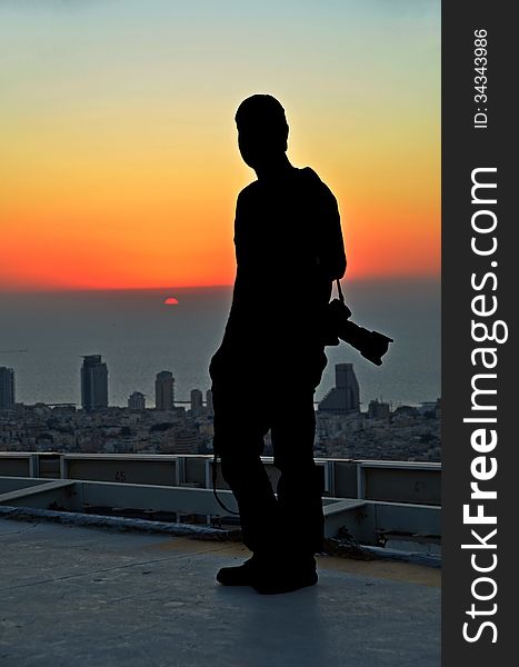 Silhouette of a photographer in the sunset from a skyscraper