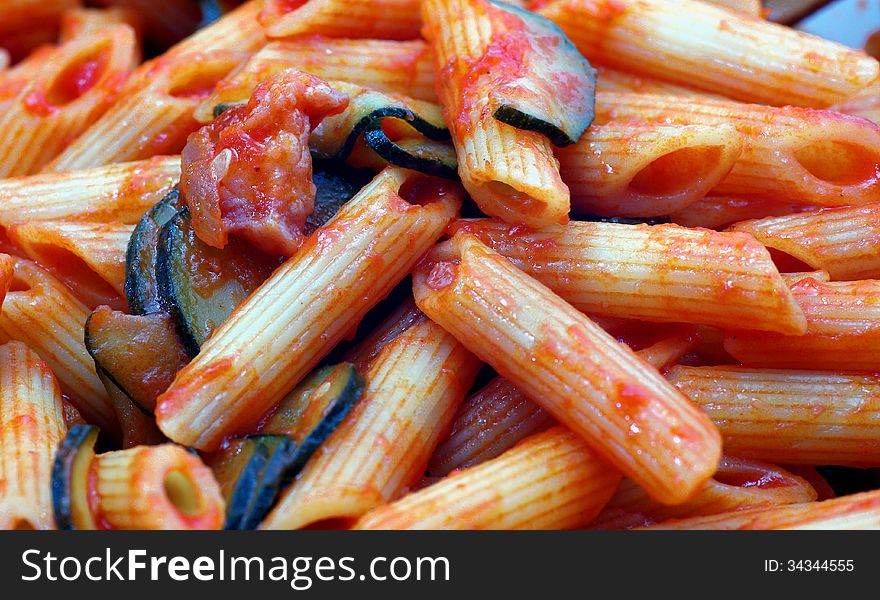 Pasta tomato sauce, zucchini and bacon a typical italian dish