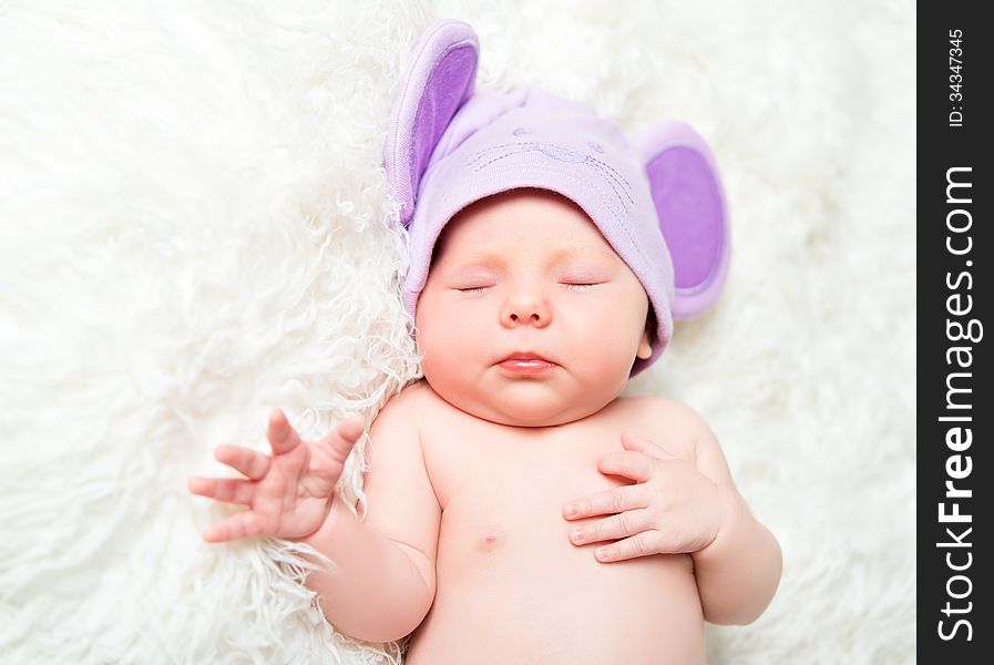 Cute newborn baby sleeps in a mouse hat with ears