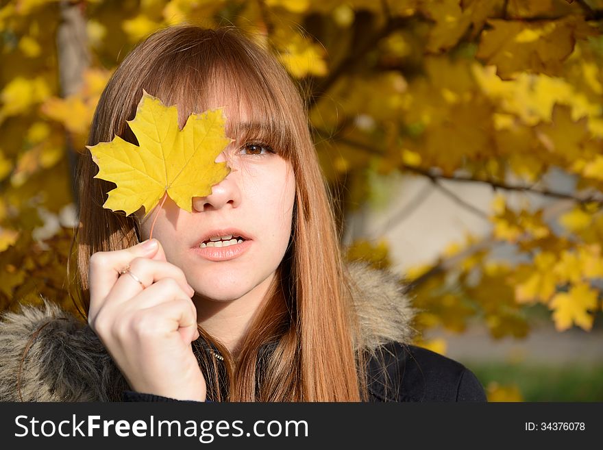 Young red-haired girl closed her eyes one sheet of yellow wedge