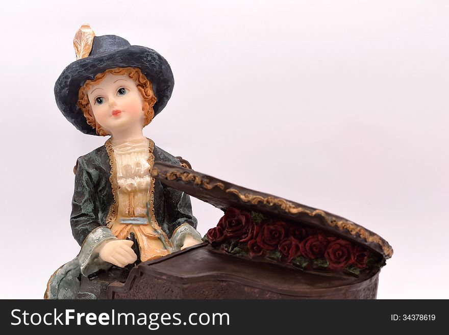 Child Porcelain pianist on white background wearing his full dress and hat