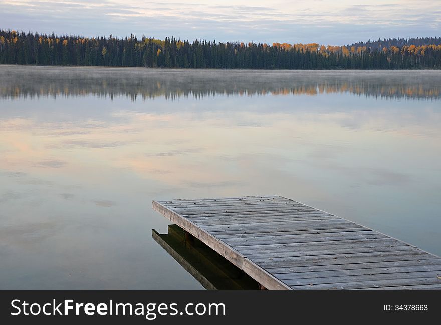 Wooden dock on calm misty morning lake. Wooden dock on calm misty morning lake