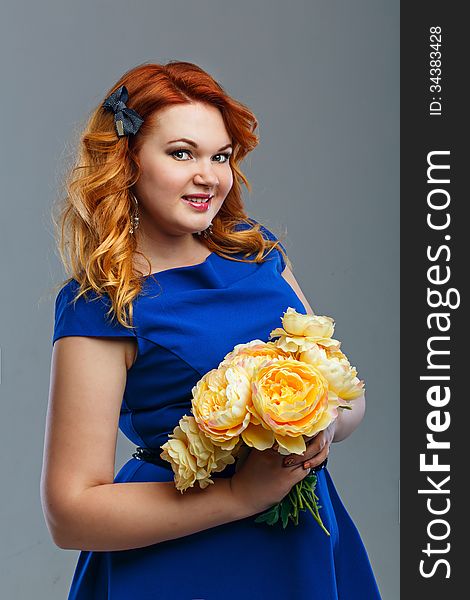 Attractive red-haired girl holding a bouquet of yellow flowers. Attractive red-haired girl holding a bouquet of yellow flowers