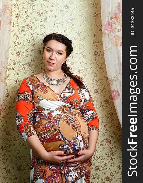 Attractive pregnant girl in a beautiful dress, shot in the studio. Attractive pregnant girl in a beautiful dress, shot in the studio