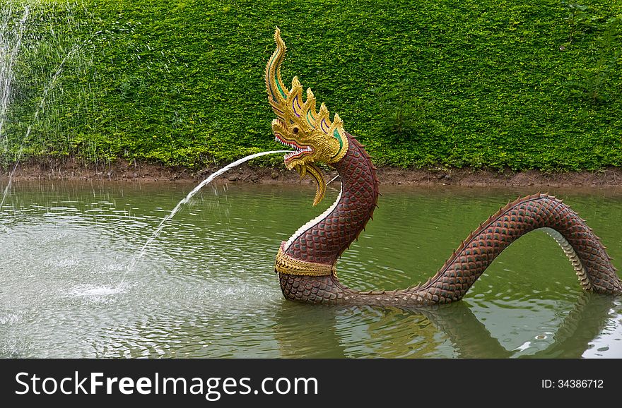 Serpent statue was spraying water out of the mouth in the river