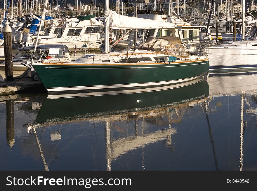 A nice green boat tied up at a marina