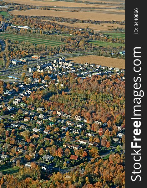 Aerial view of houses and fields in bright colors of autumn.