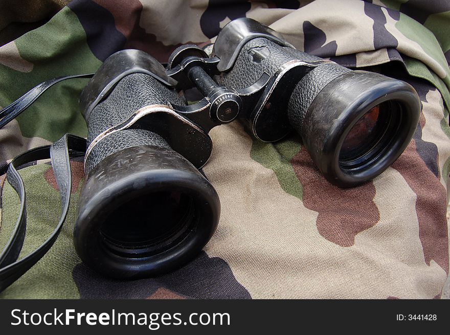 Binoculars against a camouflage background. Binoculars against a camouflage background.