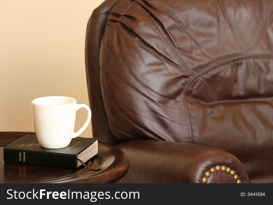 Leather chair with Bible and coffee mug sitting on table. Leather chair with Bible and coffee mug sitting on table