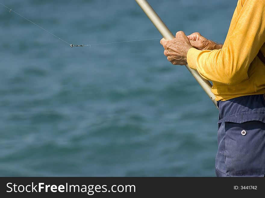 A fisherman pictured at the sea shore. A fisherman pictured at the sea shore.