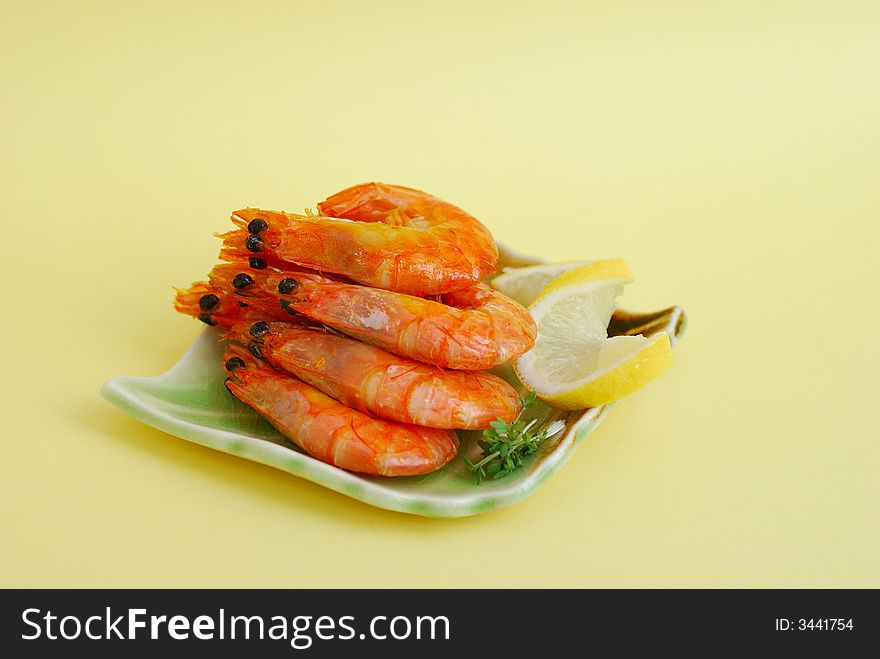Shrimp with lemon on a plate close up
