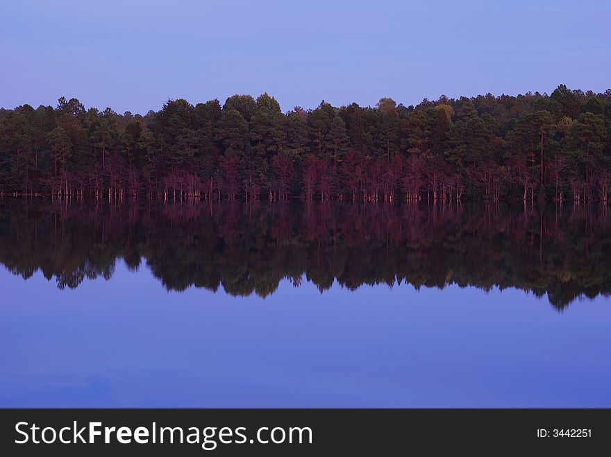 A warm purple glow in a lake reflection.In Rockingham North Carolina USA. A warm purple glow in a lake reflection.In Rockingham North Carolina USA