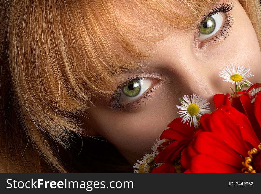 Beautiful girl's green eyes and bouquet of red flowers. Beautiful girl's green eyes and bouquet of red flowers.