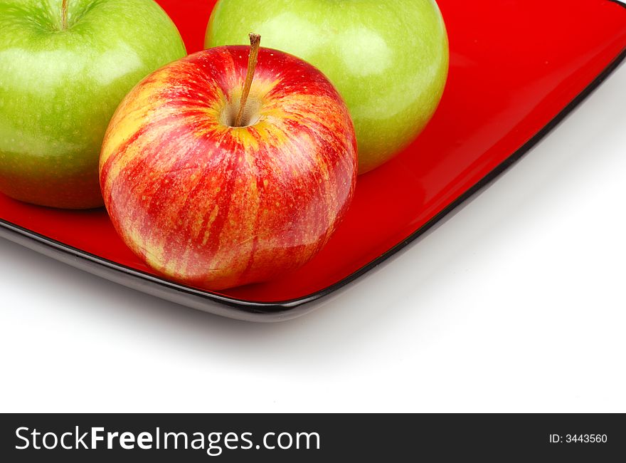 Three apples on red plate