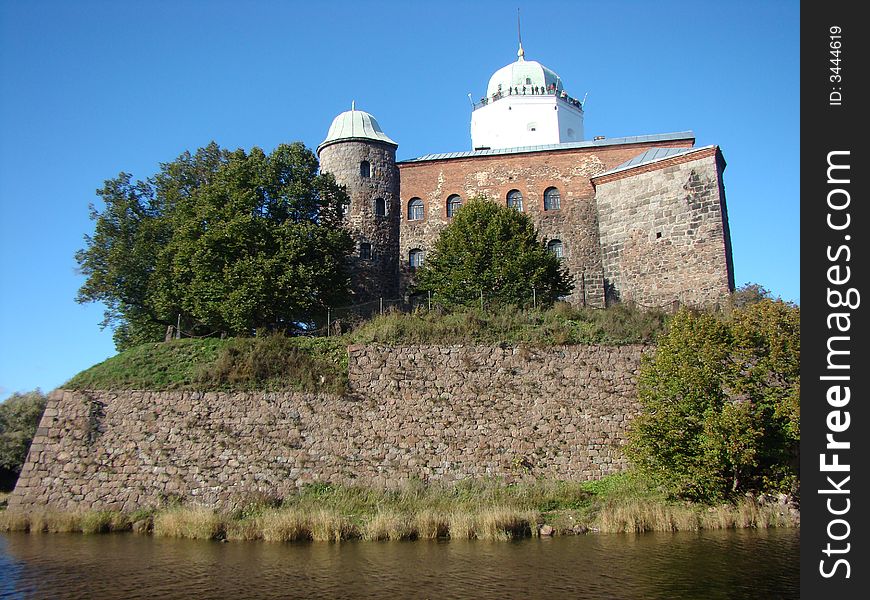 Old fortress in Russia. A protective stone wall. The fortress is surrounded by water. A monument of architecture