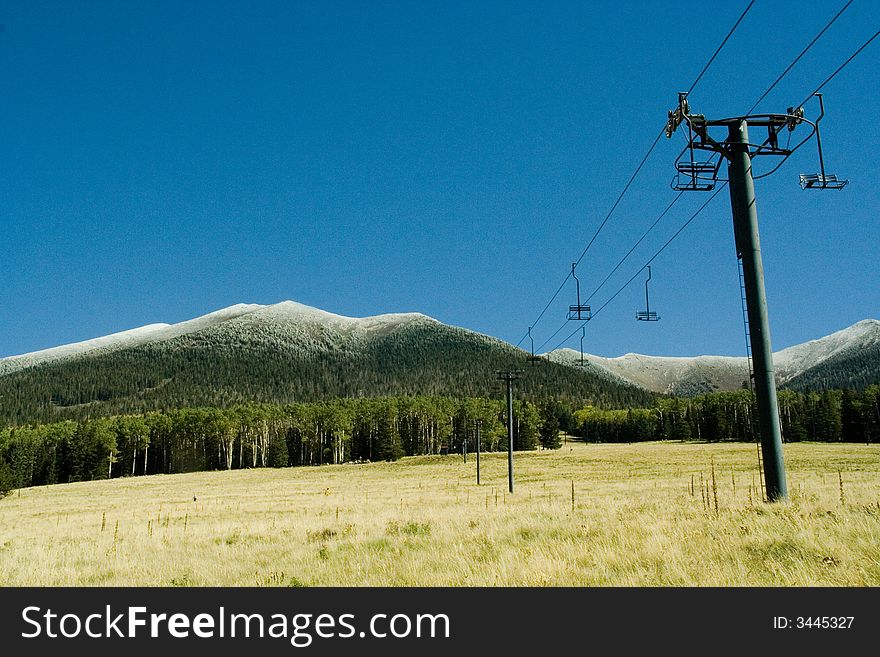 Ski lifts at ski resort with mountain snow.