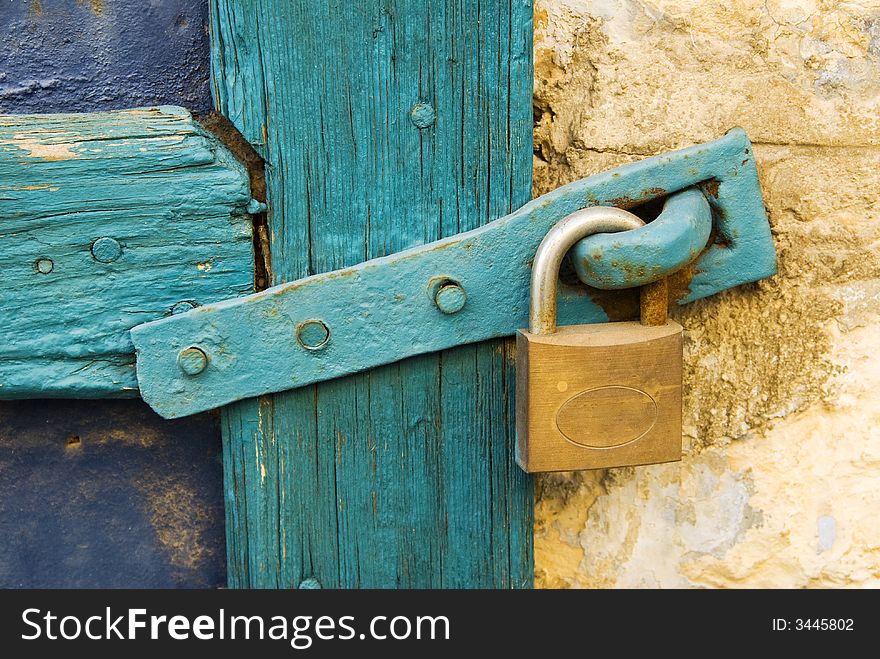 Old lock with blue wooden door frame and clasp