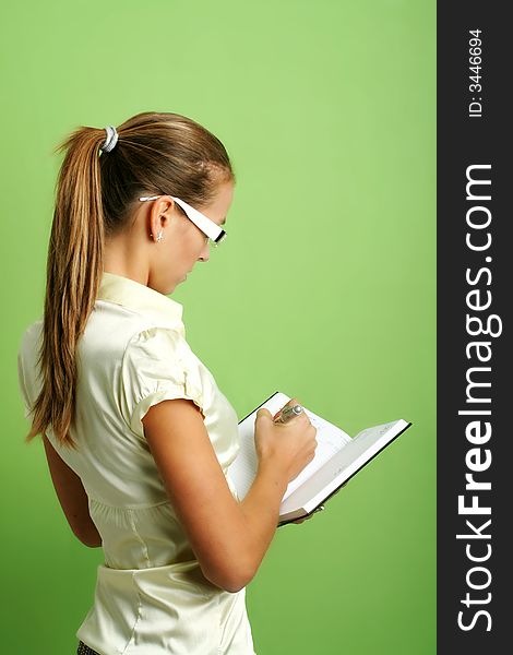 Business portrait of a young and successful woman writing at a folder. Business portrait of a young and successful woman writing at a folder