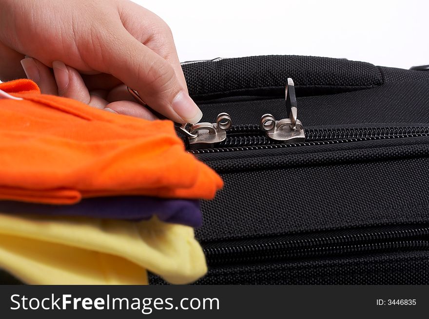 Hand opening the zipper of a black travel bag. Hand opening the zipper of a black travel bag