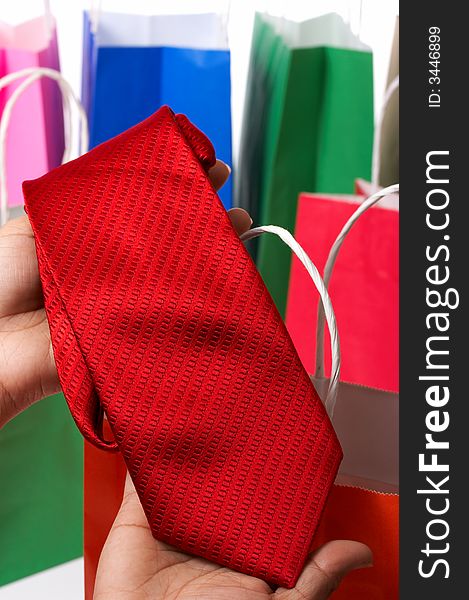 Holding a red necktie with some shopping bags on the background