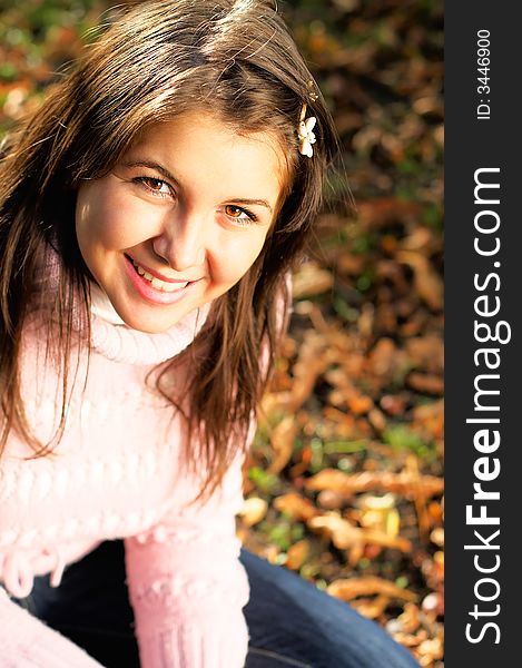 Autumn Portrait - Beautiful young girl in the park with golden light