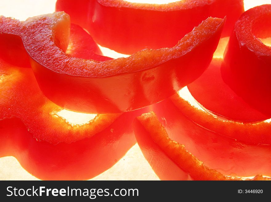 Stack of red pepper slices against white background. Stack of red pepper slices against white background