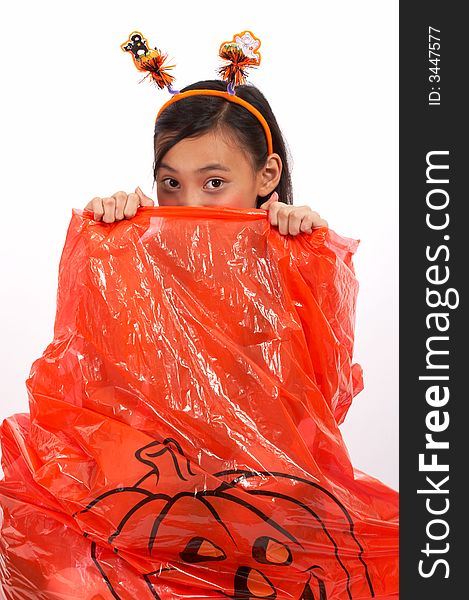 A young girl peeping from a halloween lawn bag. A young girl peeping from a halloween lawn bag