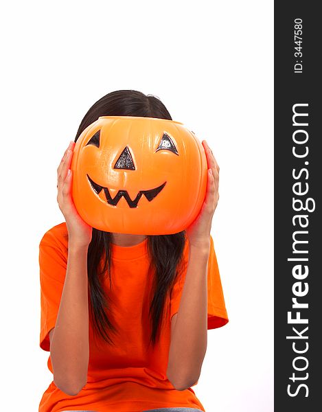 A girl holding a pumpkin covering her face over a white background. A girl holding a pumpkin covering her face over a white background