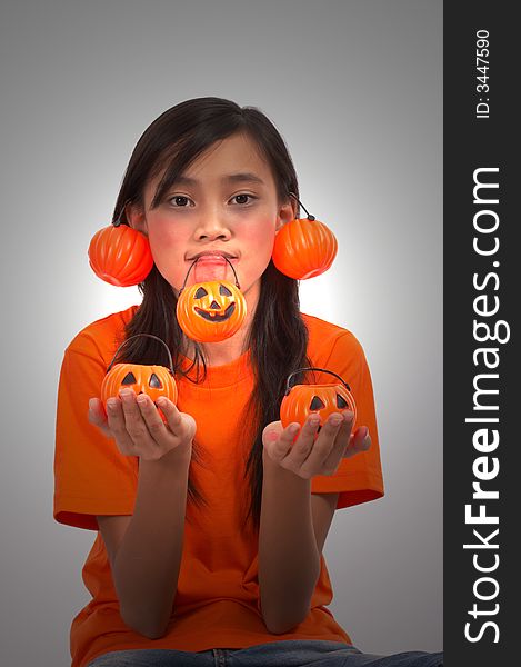 A young girl with pumpkins under a spotlight. A young girl with pumpkins under a spotlight