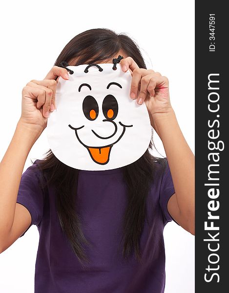 A girl holding a halloween bag covering her face. A girl holding a halloween bag covering her face